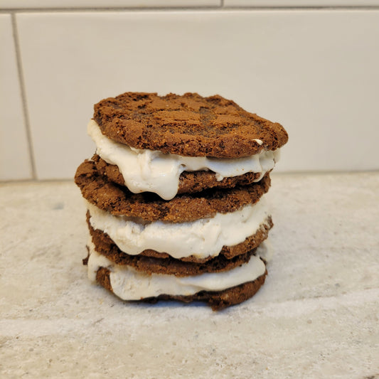 Stack of 3 brownie ice cream cookie sandwiches filled with vanilla ice cream..
