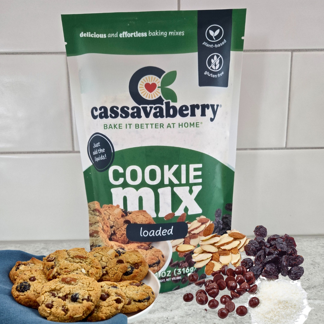 Cassavaberry Gluten free, grain free and vegan Loaded Cookie Mix package with cookies on a plate, and cranberries, coconut, chocolate chips and sliced almonds next to the package.