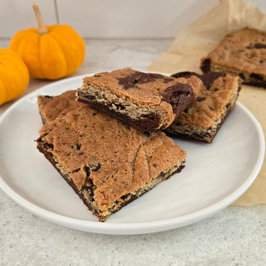 Plate of Pumpkin Spice Brookie bars with pumpkins in the background.