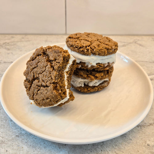 Gingersnap Ice Cream Sandwiches. Two stacked on top of each other, with one place at an angle with a bite take out of it.