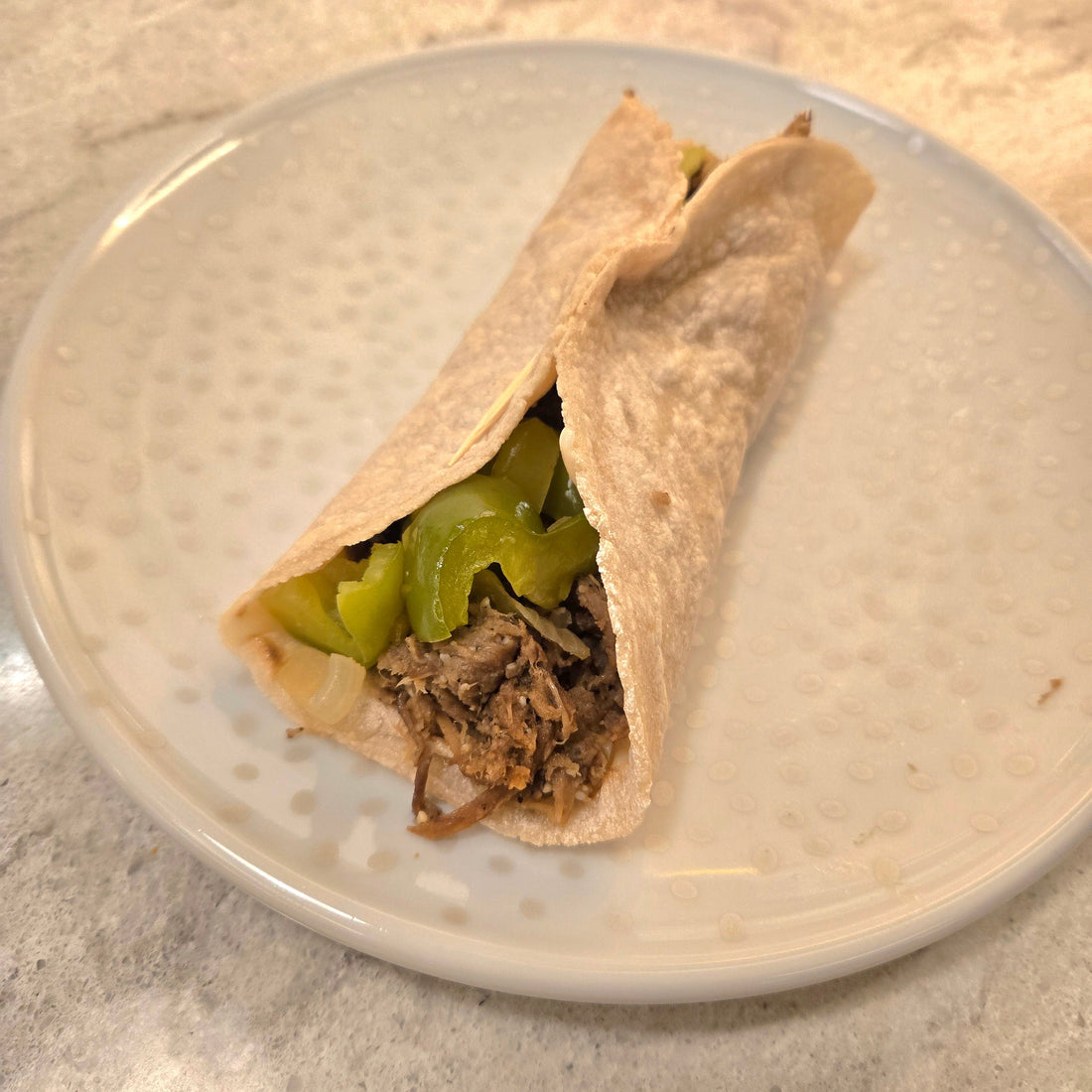 Philly Cheese Steak Mushroom wrap on a white plate with silver dots.