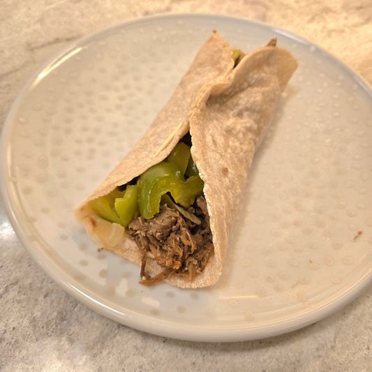 Philly Cheese Steak Mushroom wrap on a white plate with silver dots.