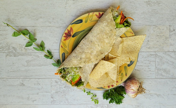 Plant-based Garlic and Herb Tortilla Wrap made with lettuce, sprouts, sweet bell peppers, tomatoes, carrots and avocado with a side of Siete grain-free tortilla chips
