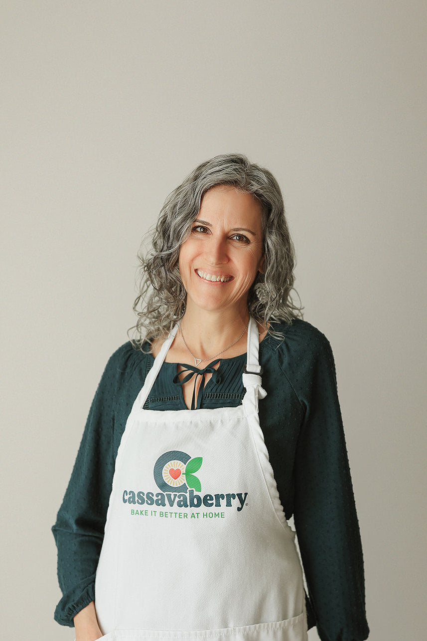 The founder Stacie is smiling while wearing a white Cassavaberry branded apron.