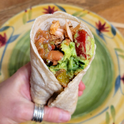 Cassavaberry Tortilla Mix made into a Burrito, held by one hand.